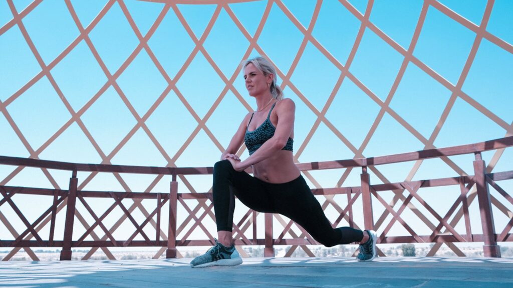 Woman in Green Sports Bra and Black Leggings Doing Leg Lunges